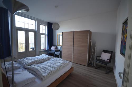sypialnia z łóżkiem i dużym oknem w obiekcie Fraai appartement direct aan zee op toplocatie. w mieście Vlissingen