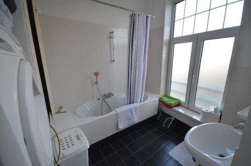 łazienka z wanną, toaletą i umywalką w obiekcie Fraai appartement direct aan zee op toplocatie. w mieście Vlissingen