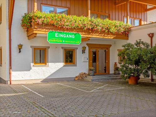 a building with a green sign in front of it at Landhotel Gabriele in Unterwössen