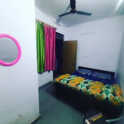 a bedroom with a bed and a ceiling fan at Hotel Himalayan Dews Ukhimath in Ukhimath