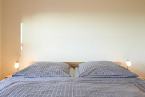 a bed with two blue pillows on top of it at Suedwind in Nordstrand