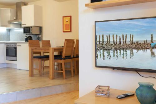 a living room with a television hanging on a wall at Suedwind in Nordstrand