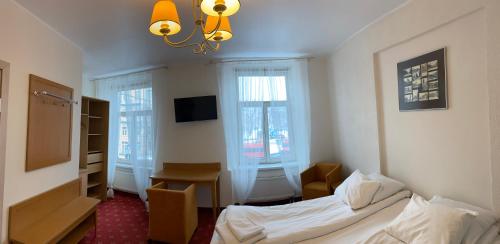 a bedroom with a bed and a desk and window at Alexa Old Town in Vilnius
