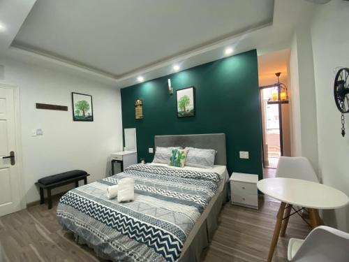 een slaapkamer met een bed en een groene muur bij Lucas Inn in Da Lat