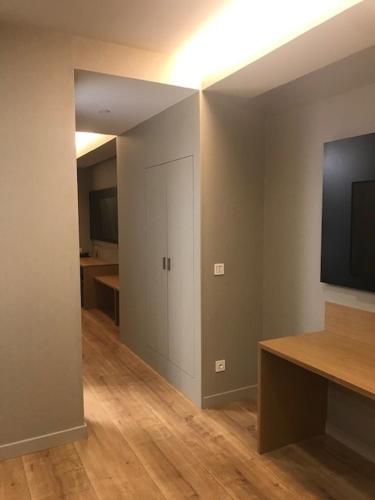 a room with a hallway with a television and a room with a table at Silken Reino de Aragón in Zaragoza