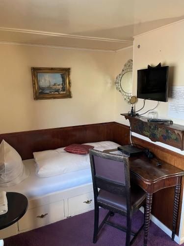a room with a bed and a desk and a computer at Schiffspension Luise in Potsdam