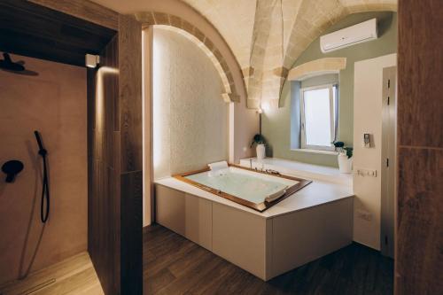 a bathroom with a bath tub and a sink at Liconti Exclusive Rooms in Pulsano