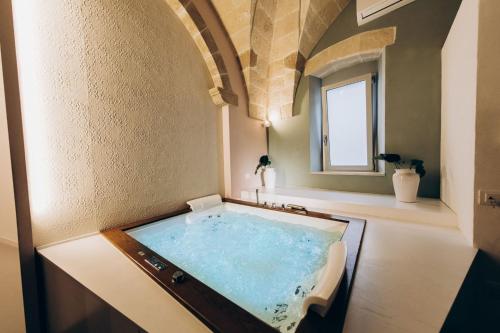 a bathroom with a large tub with a window at Liconti Exclusive Rooms in Pulsano