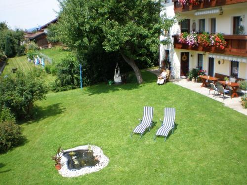 deux chaises assises dans l'herbe dans une cour dans l'établissement Gästehaus Kuchler, à Lam