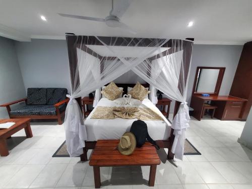 a bedroom with a bed with a canopy at Tlou Safari Lodge in Kasane