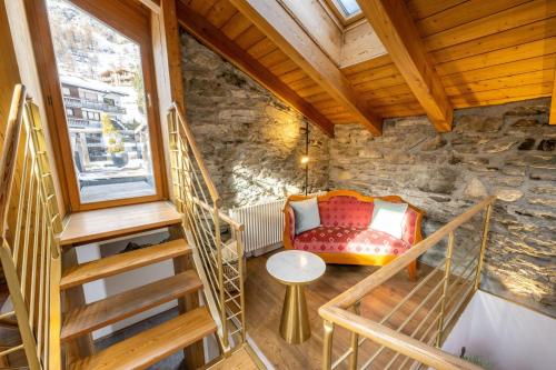 a room with a staircase and a couch in a building at Haus Genepy in Zermatt