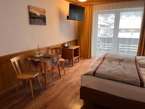 a hotel room with a bed and a table and a dining room at Hotel Löwen in Reit im Winkl