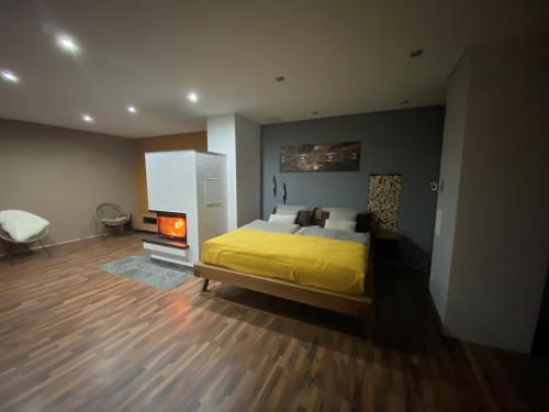 a bedroom with a yellow bed and a fireplace at Ferienwohnung 2 Schweizer in Geisingen