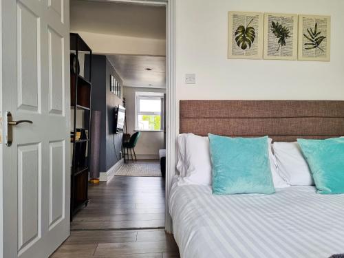 a bedroom with a bed with blue and white pillows at New Refurb Top Floor Flat in Central Cheltenham in Cheltenham