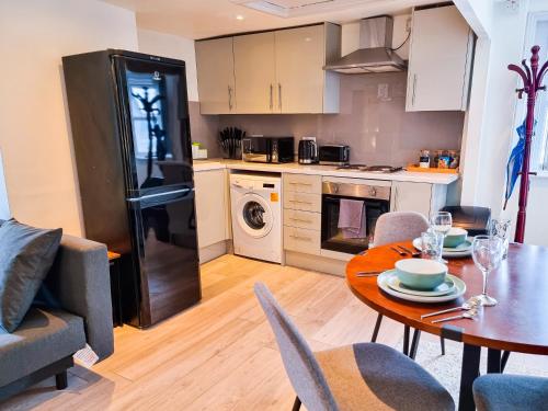 切爾滕納姆的住宿－New Refurb Top Floor Flat in Central Cheltenham，厨房以及带桌椅的用餐室。