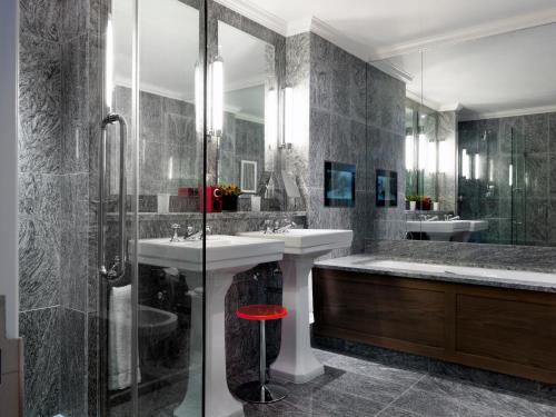 a bathroom with a tub and a sink and a shower at The Soho Hotel, Firmdale Hotels in London