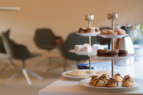 a three tiered display of pastries and donuts on a table at Hotell Conrad in Karlskrona