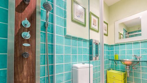 La salle de bains est pourvue de carrelage bleu, de toilettes et d'un lavabo. dans l'établissement 1Kim01 - Llafranc, à Llafranc