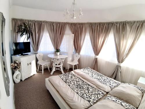 a bedroom with a bed and a table with chairs at Penzion a Restaurace Belveder Romantico, Mini-zoo, Free parking in Jáchymov