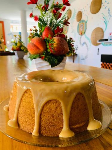 a cake with icing on a plate on a table at Flat Vila Aju in Aracaju