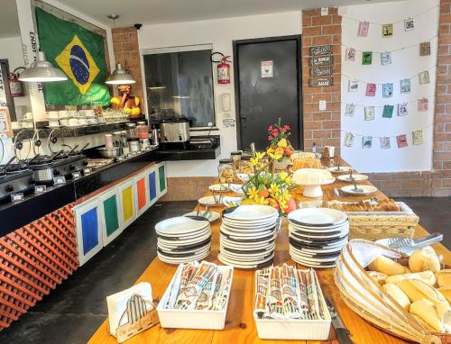 a kitchen with a table with plates of food at Flat Vila Aju in Aracaju