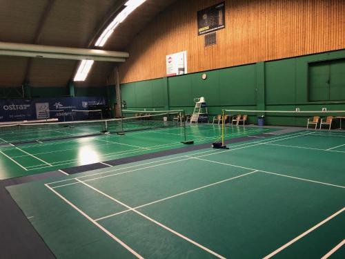 an indoor tennis court with chairs and a net at Hotel Tennis Club in Prostějov