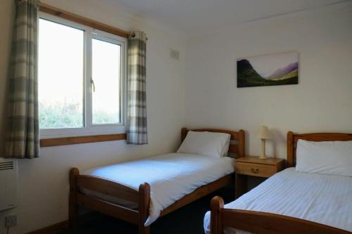 En eller flere senge i et værelse på Woodland Gean Lodge