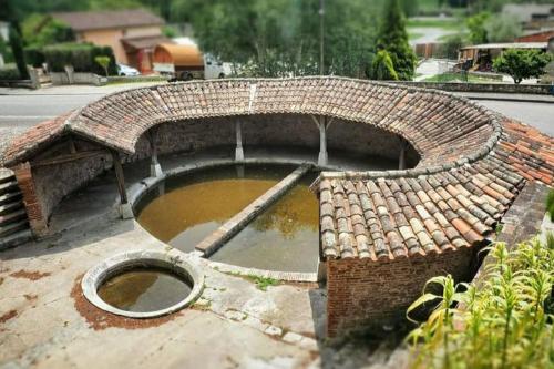 a brick building with a pond in the middle of the street at STUDIO LE NID in Valence-dʼAgen