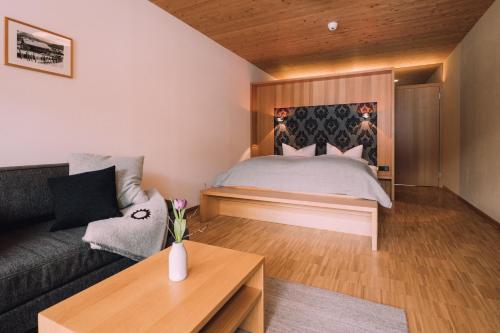 a living room with a bed and a couch at Naturhotel Chesa Valisa in Hirschegg