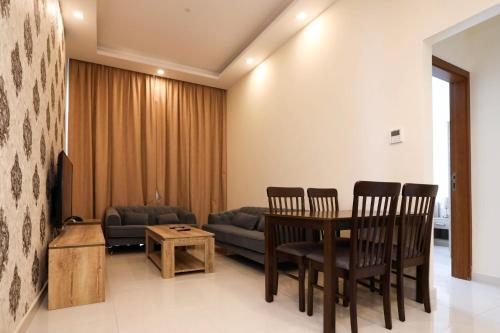 a living room with a table and chairs and a couch at The M Suite in Juffair