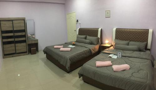 2 łóżka w pokoju z różowymi poduszkami w obiekcie Cyber Loft Homestay w mieście Ipoh