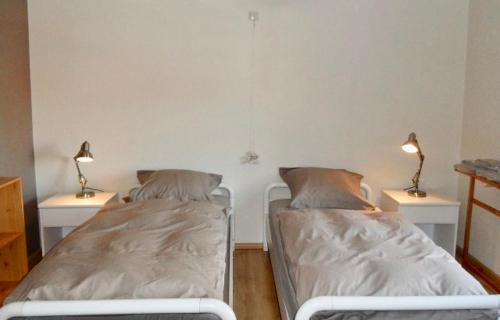 2 lits dans une chambre avec 2 lampes sur des tables dans l'établissement BENVENUTI, à Saint-Idesbald