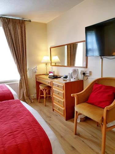 a hotel room with a bedroom with a desk and a bed at The Crown House Inn in Great Chesterford
