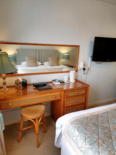 a bedroom with a desk with a bed and a mirror at The Crown House Inn in Great Chesterford