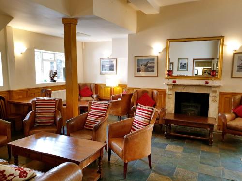 a waiting room with chairs and a fireplace at The Crown House Inn in Great Chesterford