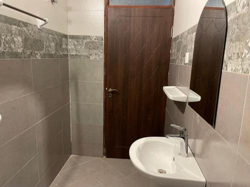 a bathroom with a sink and a toilet and a mirror at Jaffa Suites in Kampala