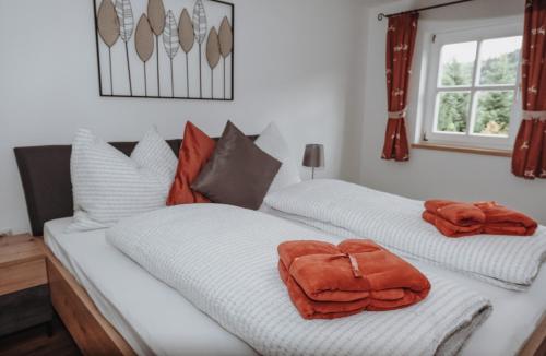 two towels are sitting on top of a bed at Hohlbichl Gut in Bischofshofen
