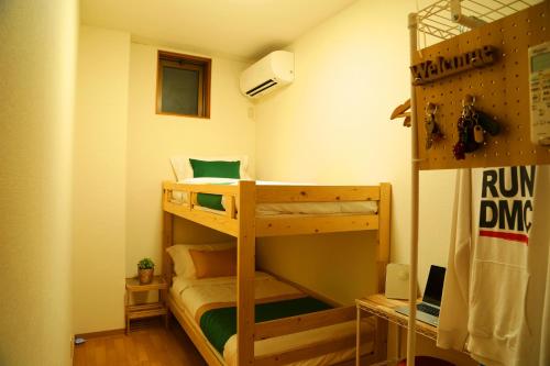 a small room with two bunk beds in it at TOKYO E JOY INN West Shinjuku Branch in Tokyo