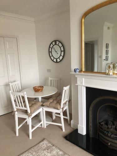 ein Esszimmer mit Tisch und Stühlen und einem Spiegel in der Unterkunft Beautiful riverfront cosy one bedroom apartment in Upton upon Severn