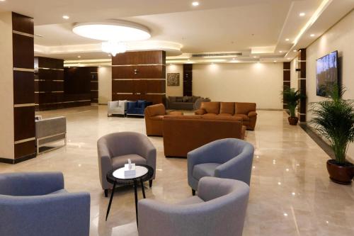 a lobby with couches and chairs and a table at The M Suite in Juffair