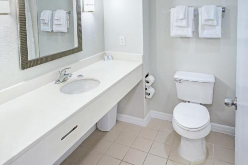 a white bathroom with a sink and a toilet at Exploria Express by Exploria Resorts in Orlando