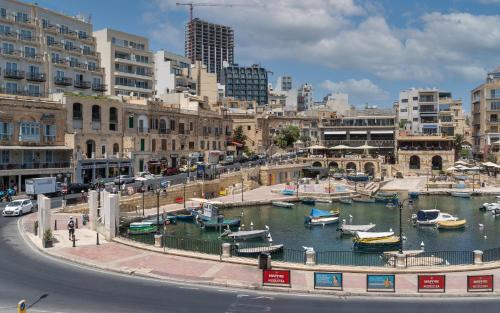a marina with boats in the water in a city at The Rose Hostel in St Julian's
