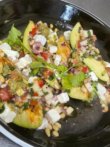 a black plate of food with vegetables and nuts at Cincis by the Lake in Cinciş