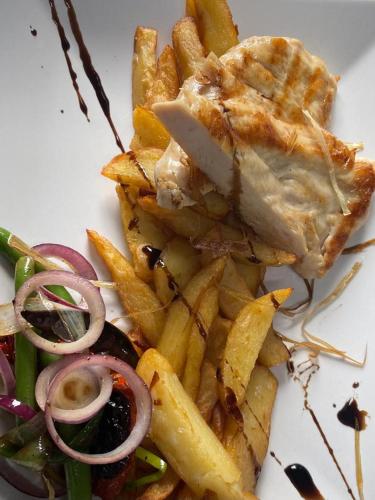 a plate of food with french fries and meat at Cincis by the Lake in Cinciş