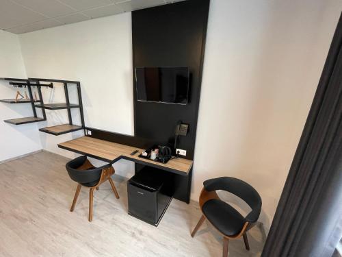 a room with a desk and two chairs and a television at Yebs Hotel in Günzburg