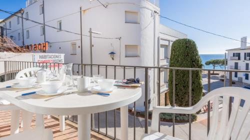 a white table and chairs on the balcony of a building at 1 Mars 1 - Llafranc in Llafranc