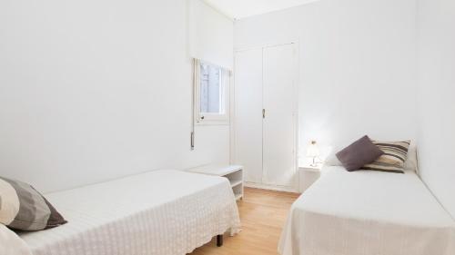 a white room with two beds and a window at 1 Mars 1 - Llafranc in Llafranc