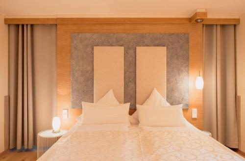 a bedroom with a large bed with white pillows at Lebensart am See in Bad Endorf