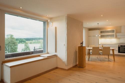 a kitchen and dining room with a large window at Lebensart am See in Bad Endorf