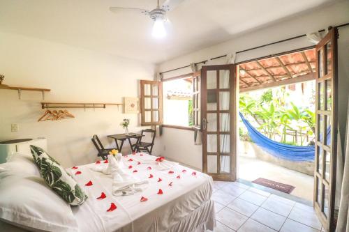 a bedroom with a bed and a large window at Pousada Aconchego da Pipa in Pipa